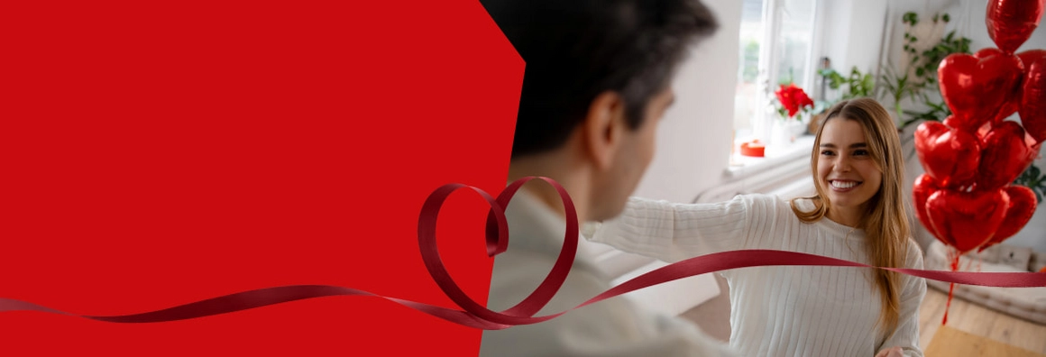 Lächelnde Person mit roten Herzballons und einem Band in Herzform.